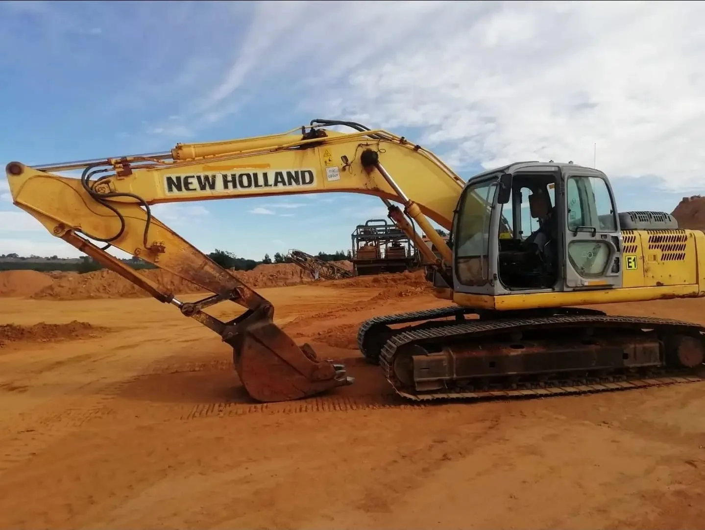 A New Holland tracked excavator on a levelled working area.
