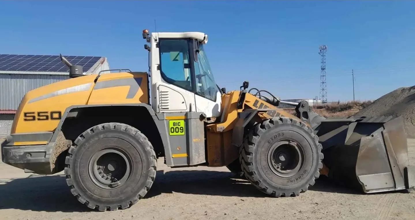 A yellow and white Liebherr L550 wheel loader marked BIC 009.